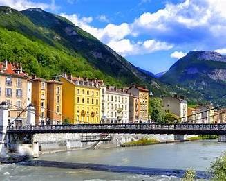 Colourful riverside town with mountains behind